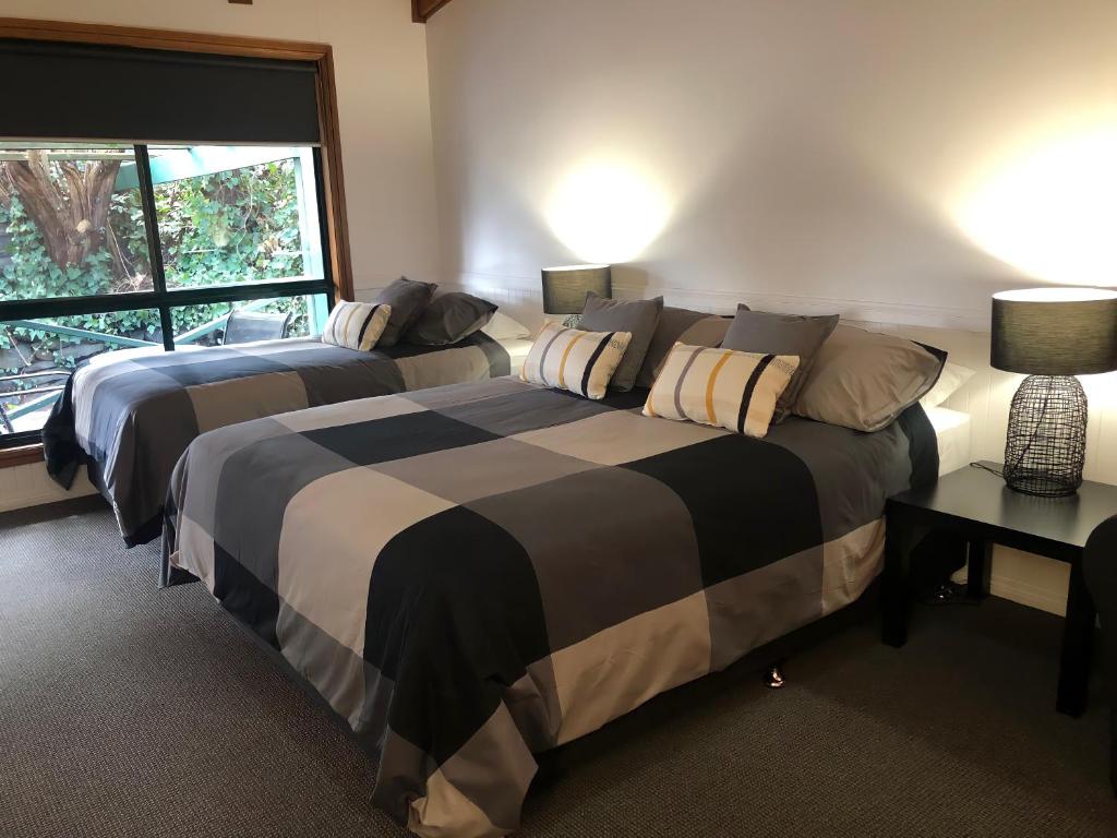 TumbarumbaBlack Range Lodge的一间卧室设有两张床和窗户。
