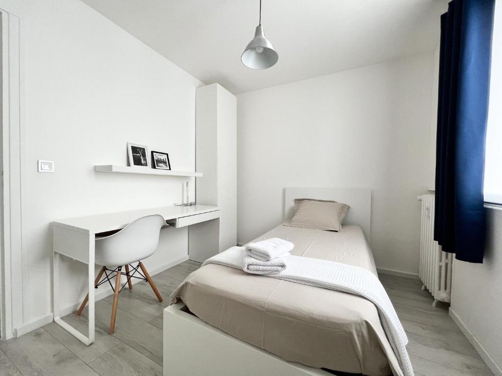 埃夫勒Une pause à Evreux logement entier的一间白色的小卧室,配有一张床和一张书桌