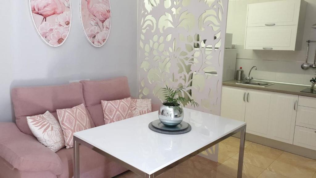 科尔多瓦Apartamento Los Padrinos的客厅配有白色桌子和粉红色沙发
