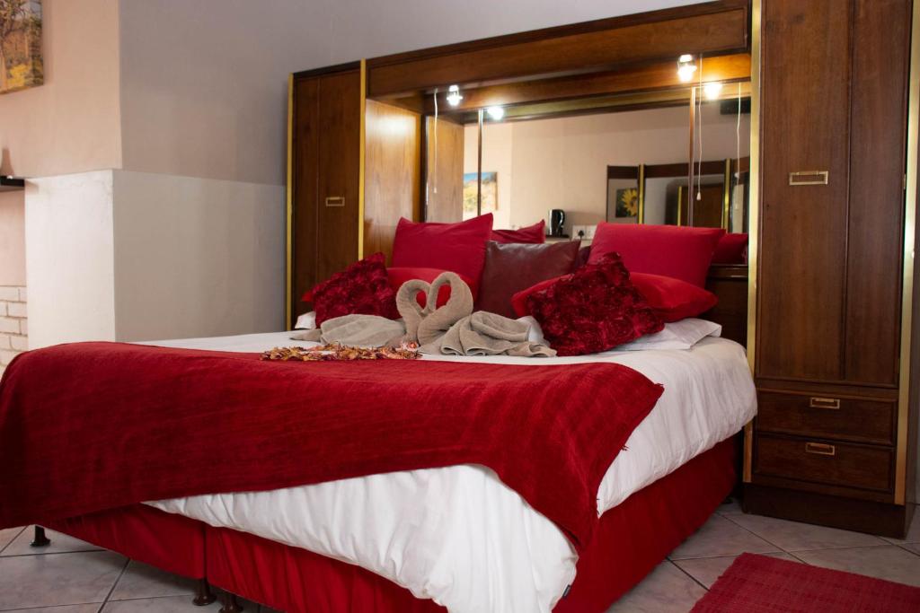 VanrhynsdorpNamaqua Lodge的一间卧室配有一张带红色枕头的大床