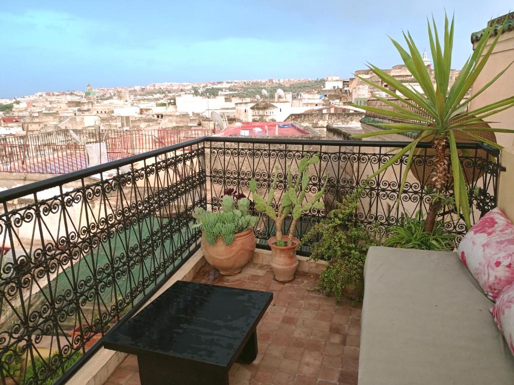 非斯Dar Azahara的阳台配有桌子和盆栽植物