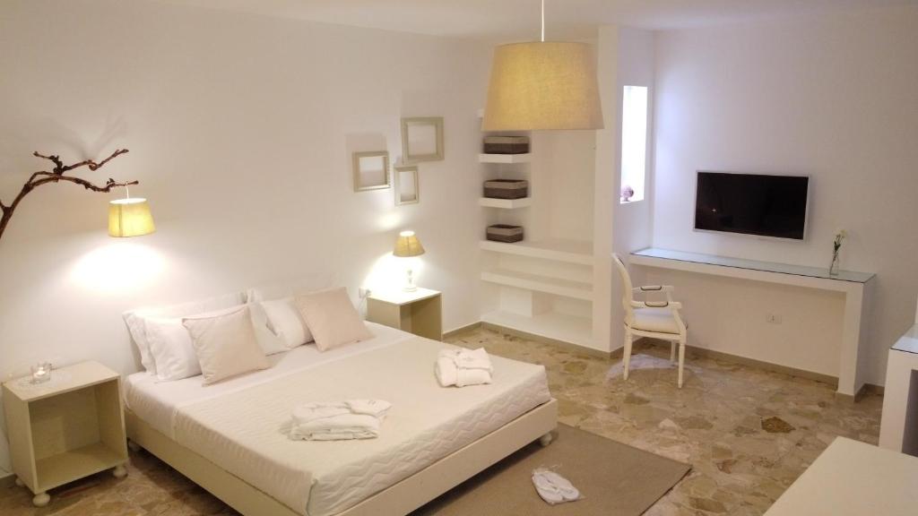乌真托Dimora TerraNostra&Spa的一间白色卧室,配有床和电视