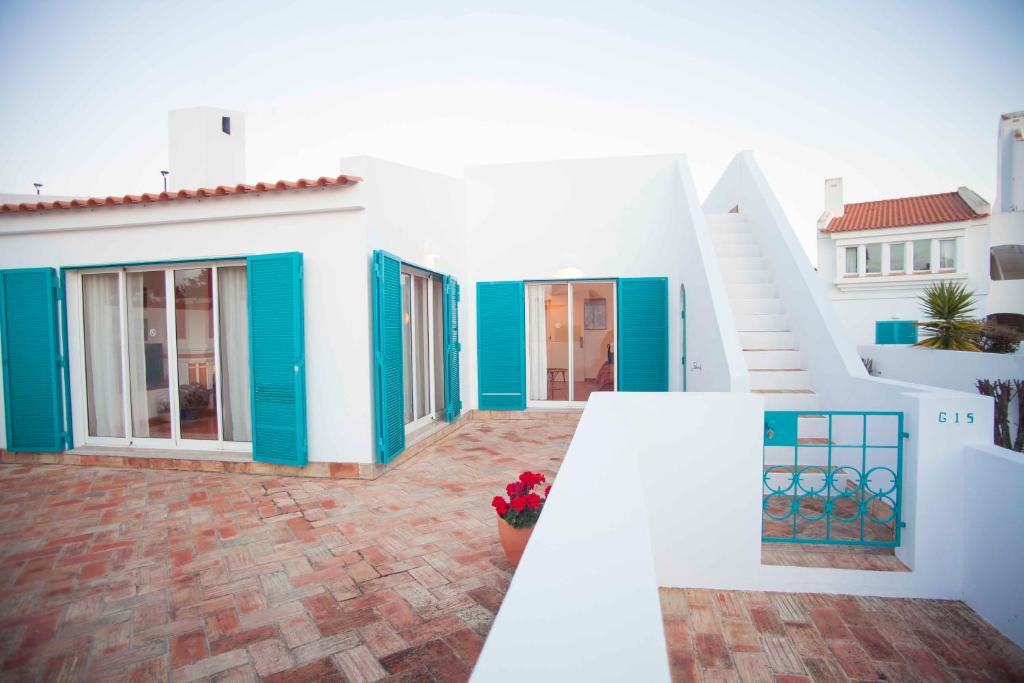 阿尔沃尔Cozy summer house的白色的房子,有蓝色的门和楼梯