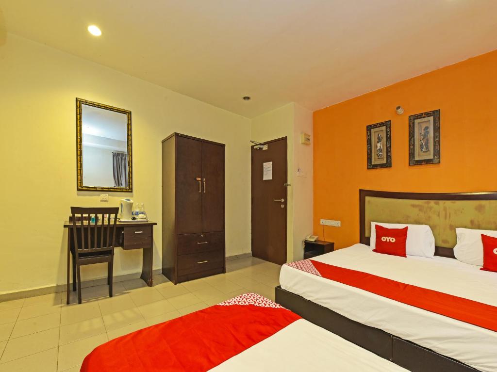 新山OYO 90510 Hotel Sahara的酒店客房配有两张床和一张书桌