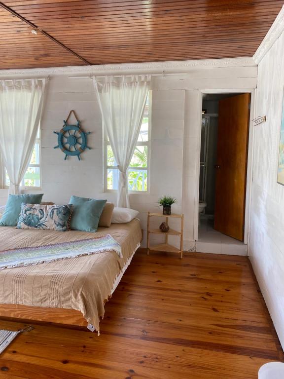 圣安德烈斯岩石礁海滩岛民度假屋的一间卧室设有一张带木制天花板的大床