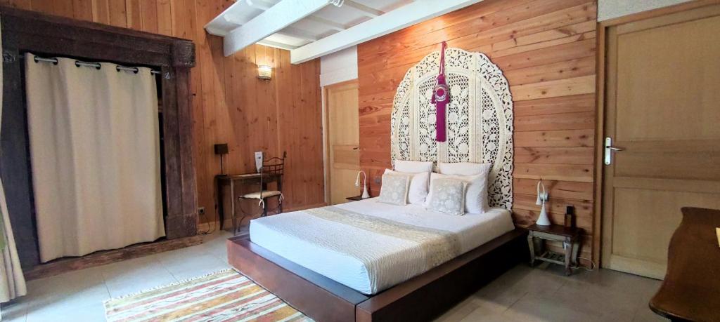 瓦隆蓬达克Couleurs du Sud的一间卧室,配有一张华丽的床头板