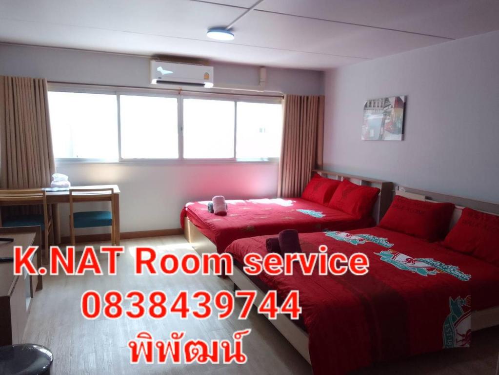 暖武里府K.NAT Room service的一间卧室,配有红色的床和红色客房服务标志