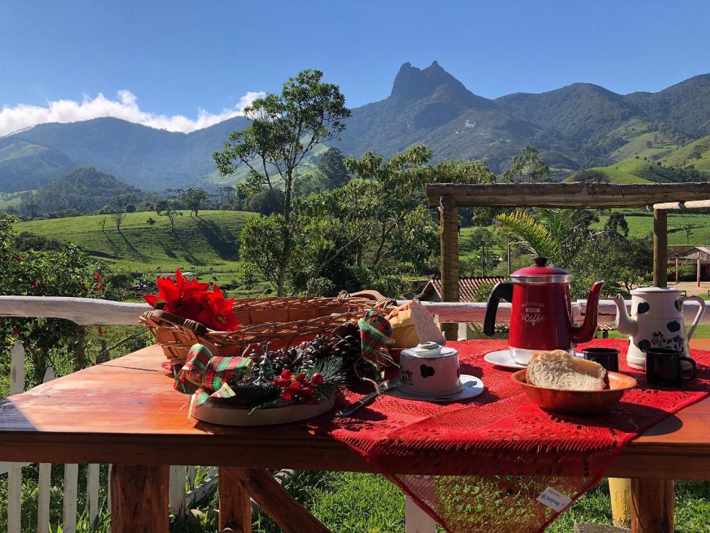 维奥康德马奥Chalé jeito de roça na Pedra Selada的一张野餐桌,上面有一篮子的山地食物