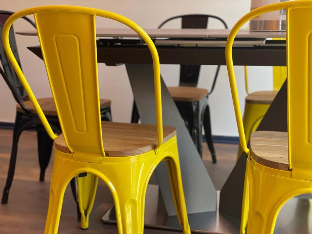 圣地亚哥TQCaleta Providencia Barrio Italia的两张黄色椅子坐在桌子旁