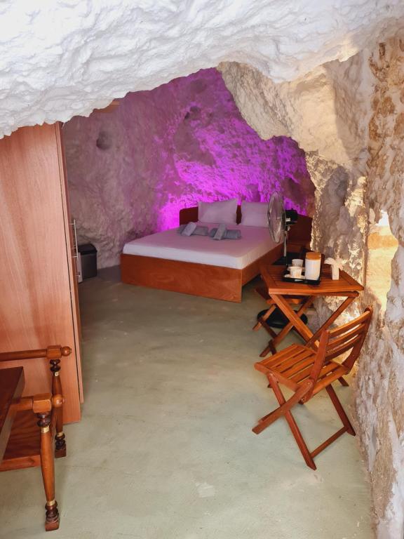 海若克利欧Anassa Cave by Estia的洞穴内一间卧室,配有一张床和一张桌子