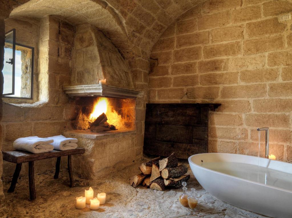 马泰拉勒格罗泰德拉奇维塔酒店的带浴缸和壁炉的石质浴室