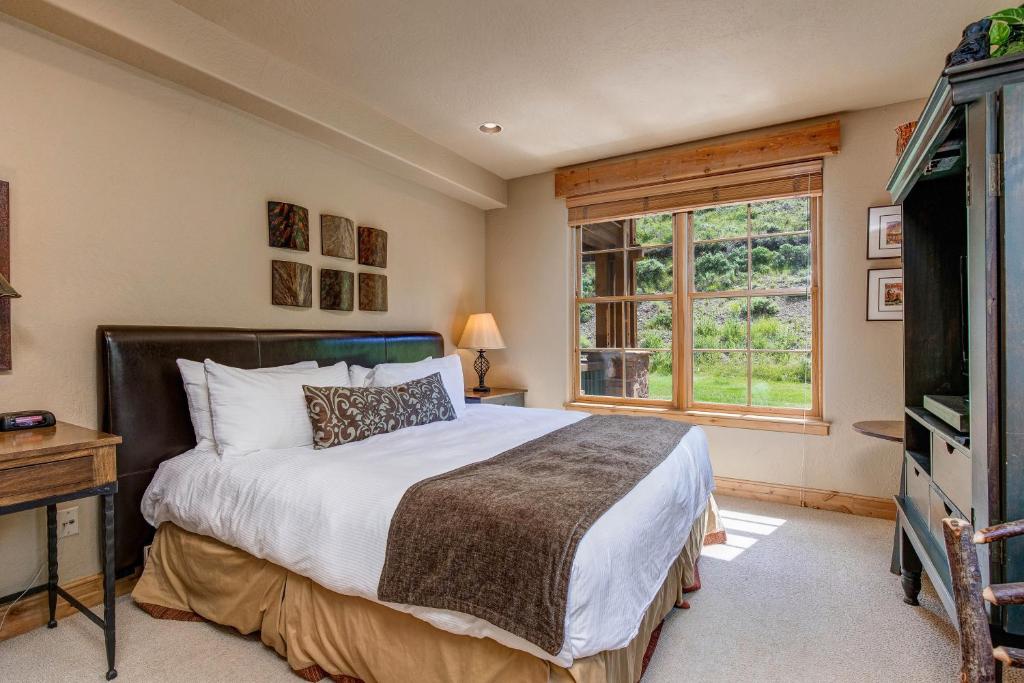 帕克城Lodges at Deer Valley - #2220的一间卧室配有一张床、一台电视和一个窗口