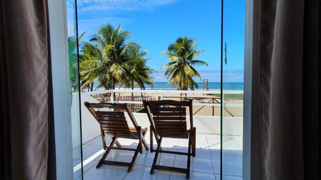 盖比姆Pousada Sol Nascente的一个带桌椅和海滩的阳台