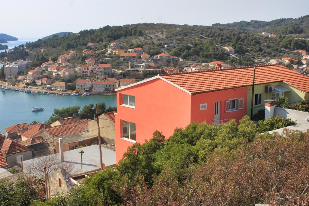 尼亚卢卡Apartments with a parking space Vela Luka, Korcula - 7551的水体旁山丘上的房屋