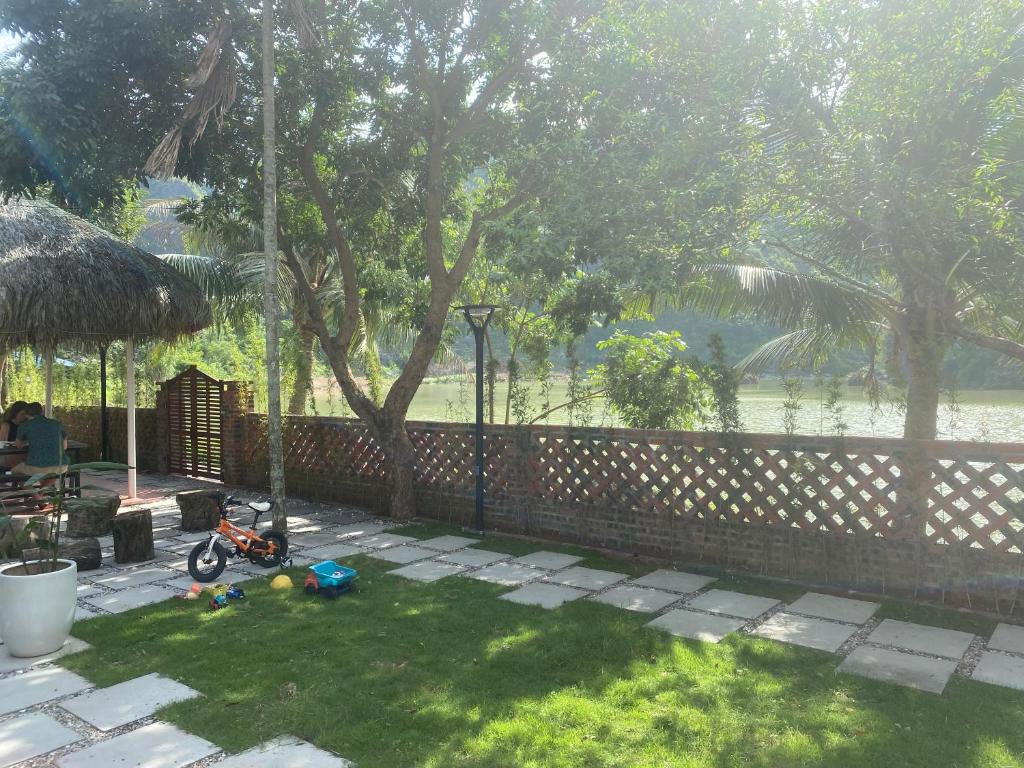 吉婆岛CornerCatBa的草地上带栅栏和儿童自行车的院子