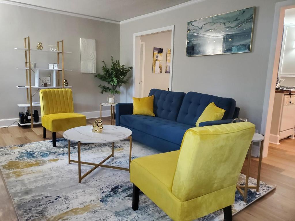 蒙哥马利Cheerful 2 BR Near Colleges, Downtown, Attractions的客厅配有蓝色的沙发和2把黄色的椅子
