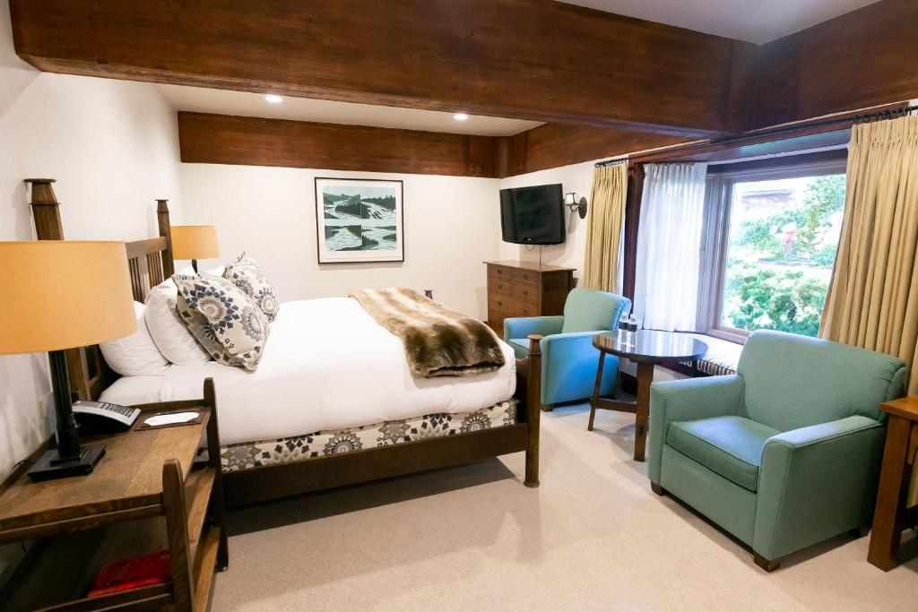 帕克城Deluxe King Room Hotel Room的卧室配有一张床、一张桌子和椅子
