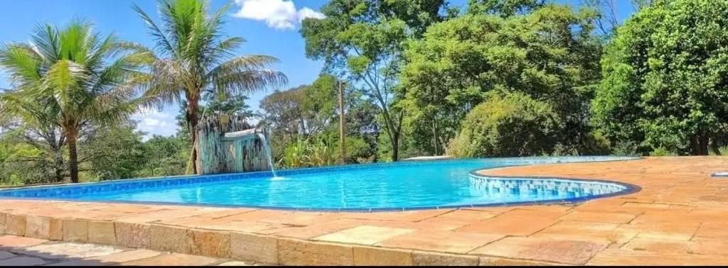 戈亚斯州科伦巴Hotel Fazenda Serra da Irara的一座树木繁茂的庭院内的游泳池