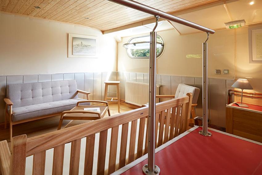 瓦兹河畔欧韦Péniche Daphné's的客厅配有长凳和沙发
