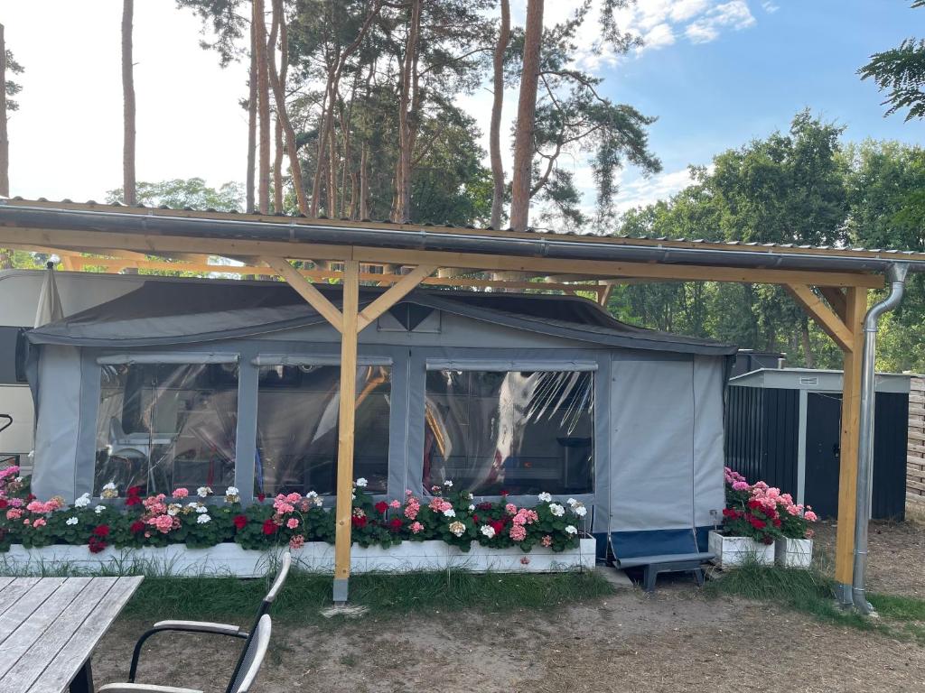 PlauePrestige Camping Brandenburg的一个带鲜花和桌子的凉亭