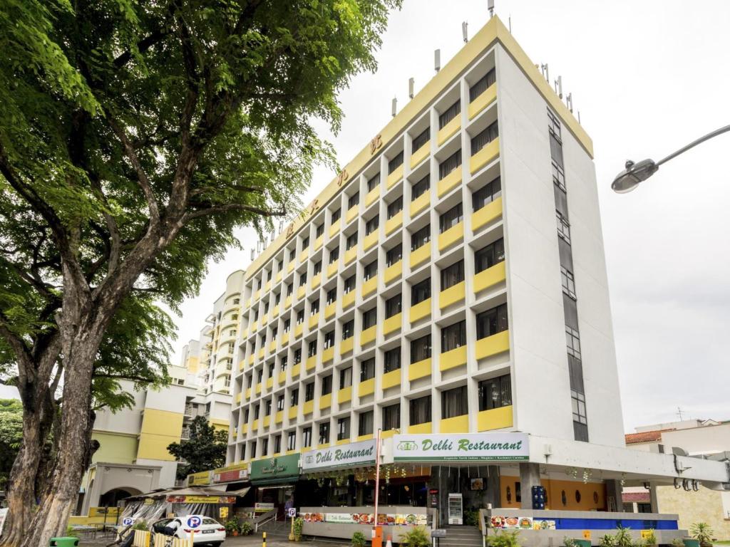 新加坡L Hotel at Broadway的白色的大建筑,带有黄色的点缀