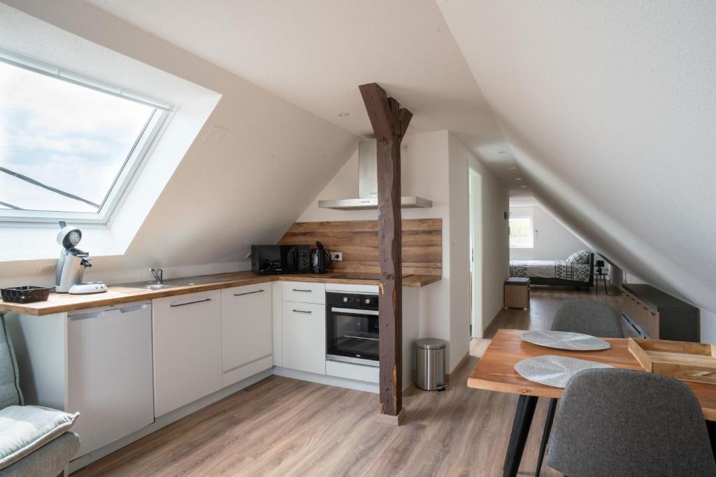 维桑堡Gemütlich 7 - Appartement cosy climatisé的厨房配有白色橱柜、桌子和窗户。