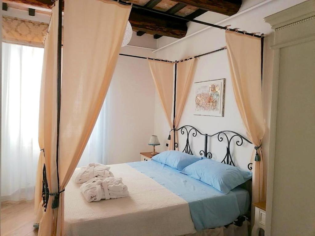 诺切劳恩布拉Residenza il Duomo的一间卧室配有一张带毛巾的天蓬床。
