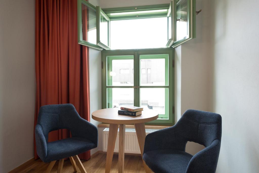 伊赫拉瓦Hotel Tři knížata的窗户客房内的两把椅子和一张桌子