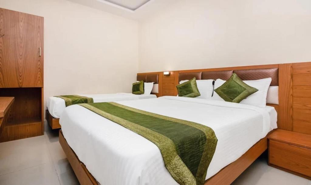 孟买Hotel Volga Plaza的白色墙壁客房的两张床