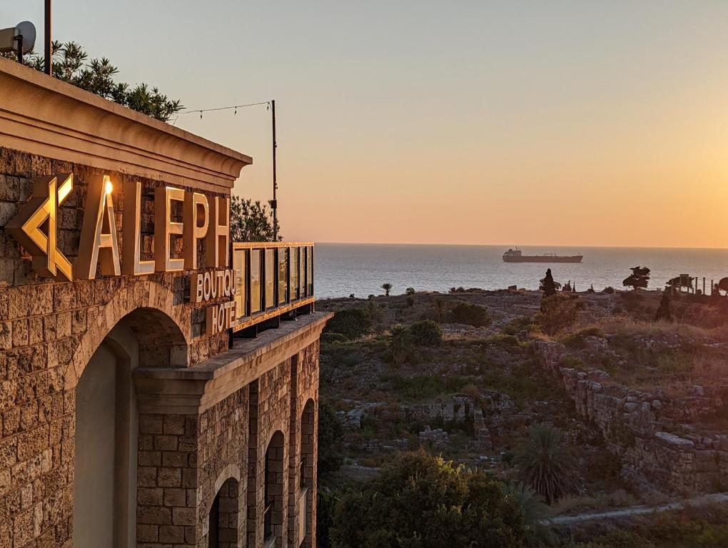 朱拜勒艾礼富精品酒店的建筑的侧面,以海洋为背景的标志