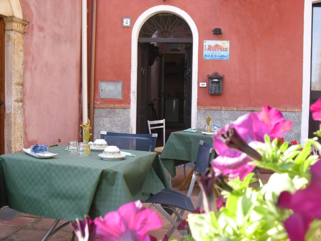 里波斯托里波斯托贾雷伊马斯特拉兹住宿加早餐旅馆的一座带粉红色花卉的建筑前的桌椅