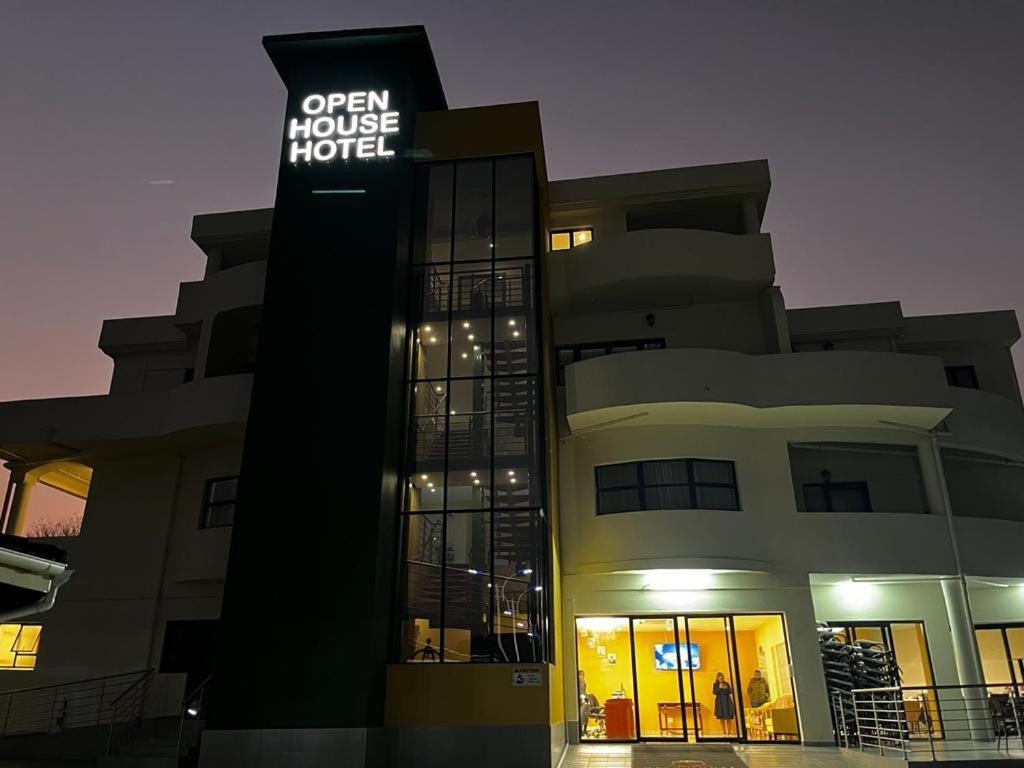 姆巴巴内Open House Hotel的一座建筑,上面有标志,上面写着可读取开放式酒店