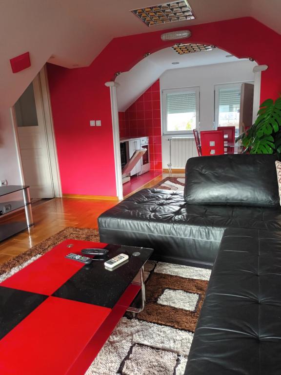比耶洛波列Sve u jednom的客厅配有黑色真皮沙发和红色墙壁