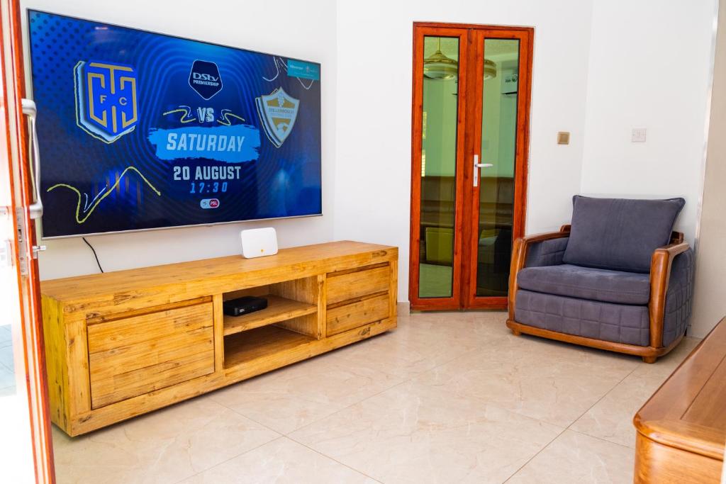 哈博罗内Gukurume- Gaborone的客厅配有电视和椅子