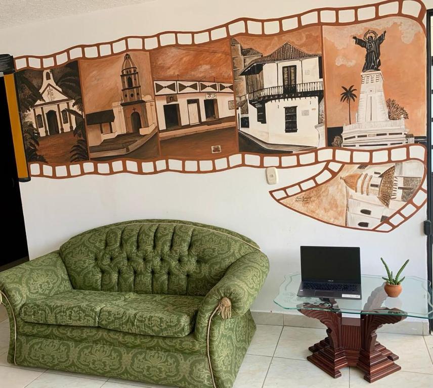 OcañaHotel San Cayetano的一张绿色沙发,位于一个墙上,画着画