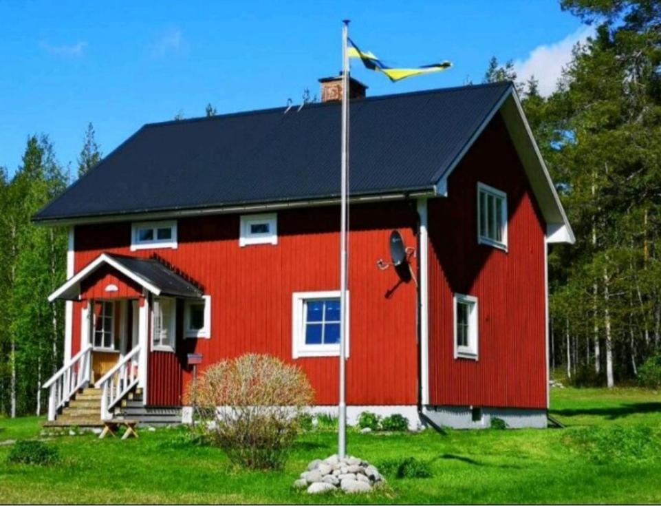 吕克瑟勒,,Björklunda" cozy apartment in swedish lapland的前面有旗帜的红色房子