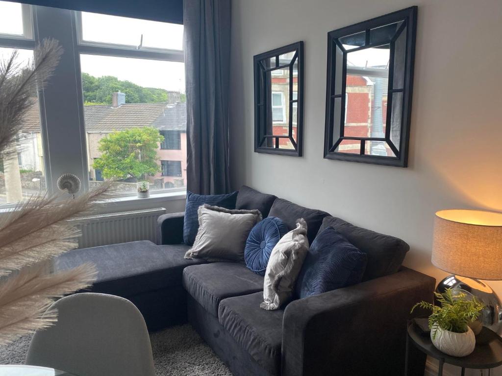 Kenfig HillThe Retreats 2 Kenfig Hill Pet Friendly 2 Bedroom Flat with King Size bed twin beds and sofa bed sleeps up to 5 people的坐在客厅沙发上的猫