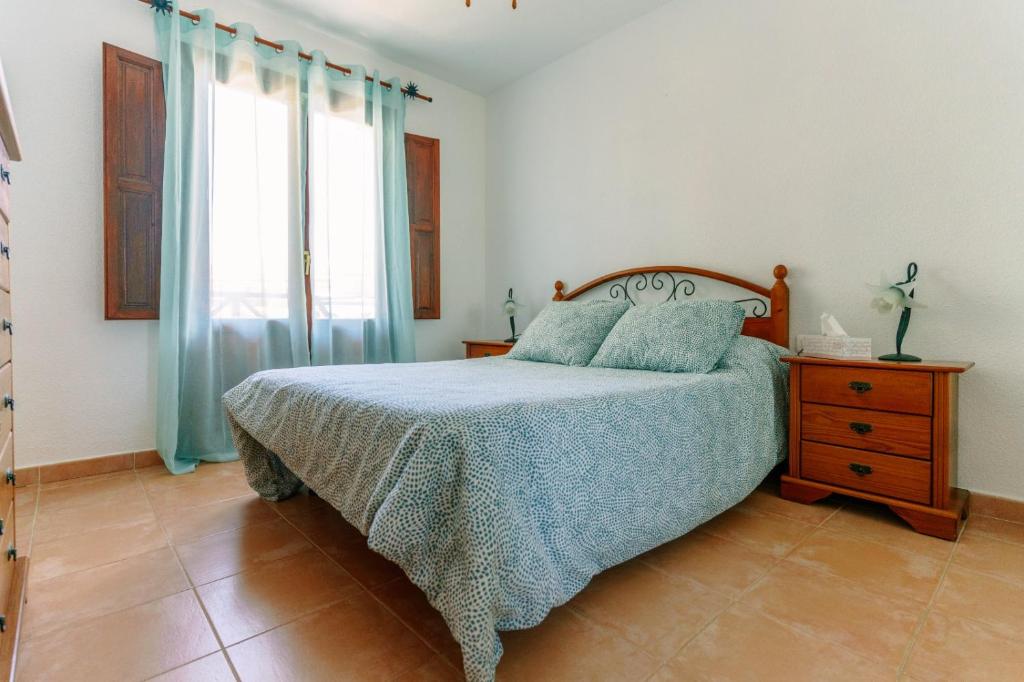 洛思坎加约斯Starfish playa的一间卧室配有一张床、一个梳妆台和一扇窗户。