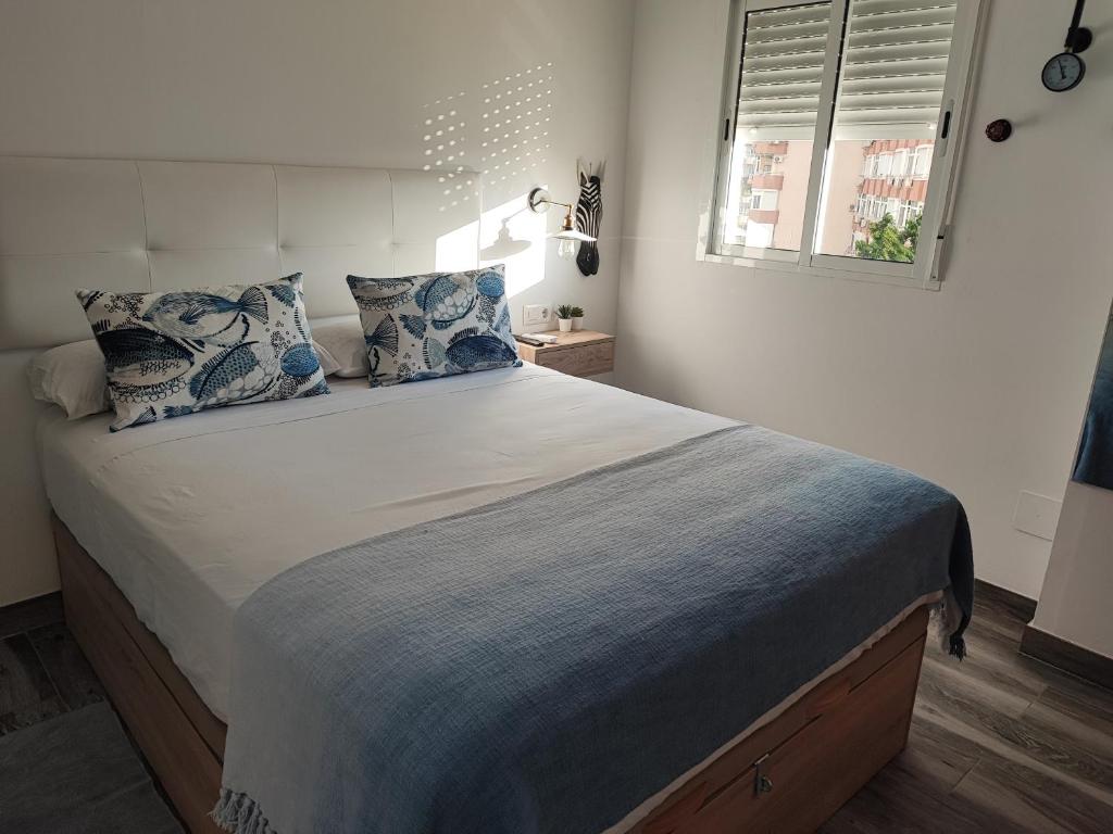 多列毛利诺斯Torremolinos Suite的一间卧室配有一张带蓝色枕头的大床