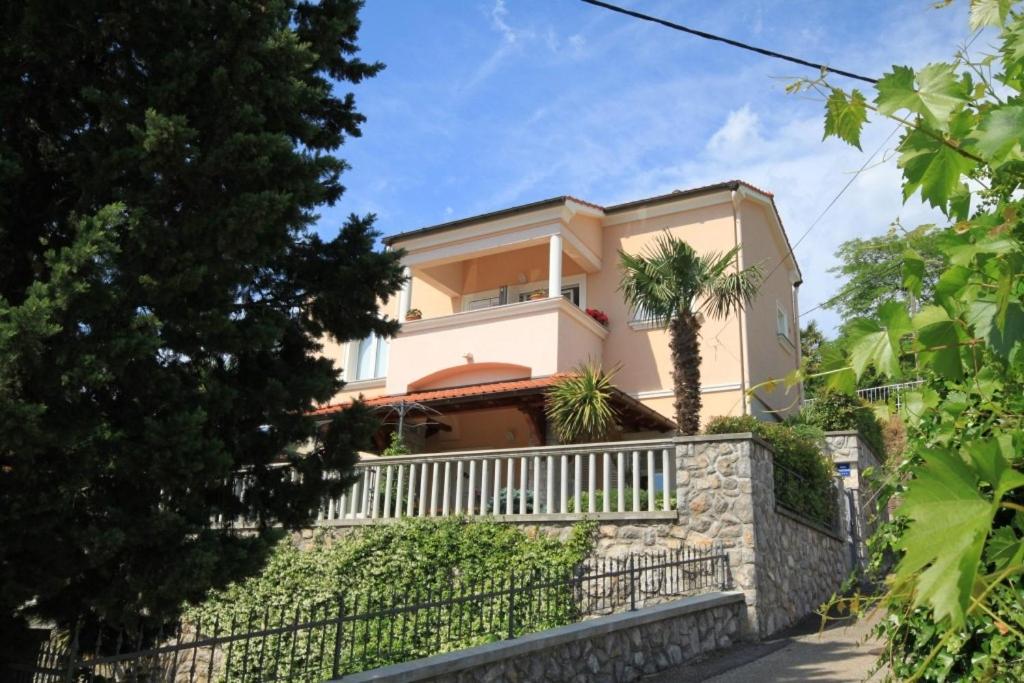 洛夫兰Apartments with a parking space Lovran, Opatija - 7782的石墙上带围栏的房子