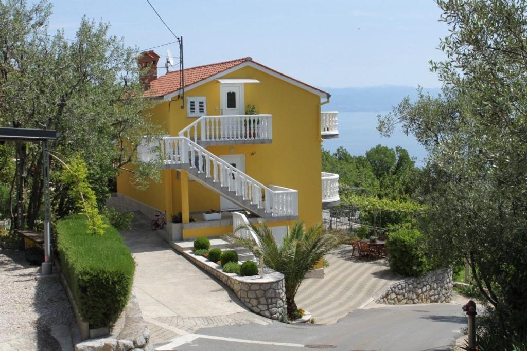 密德维亚Apartments with a parking space Medveja, Opatija - 7721的黄色的房子,前面有楼梯