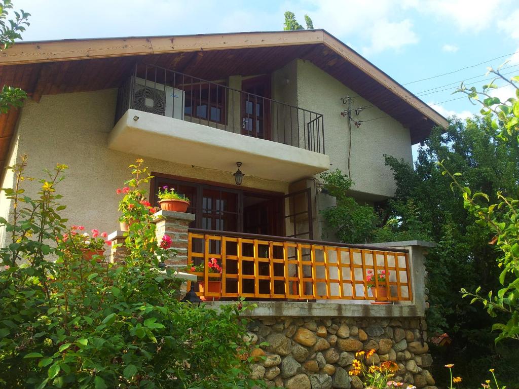 丘斯滕迪尔Къща за гости Каза Роза - Swiss Style Chalet Casa Rosa Guest House的一座带橙色门和阳台的房子