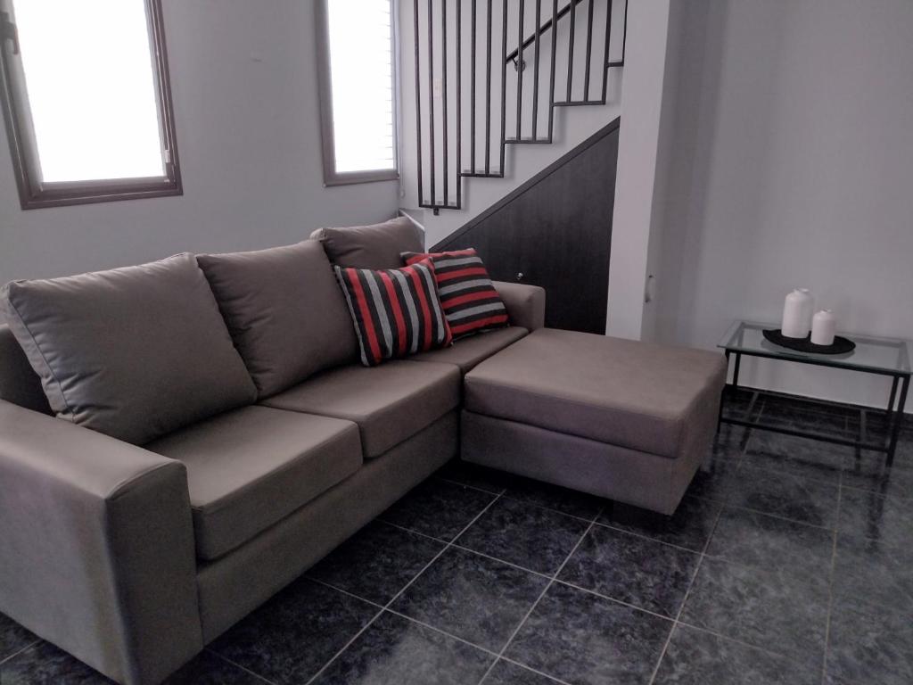 迈普Apartamento Agur cerca del Arena Stadium的客厅里设有一张棕色沙发,设有楼梯