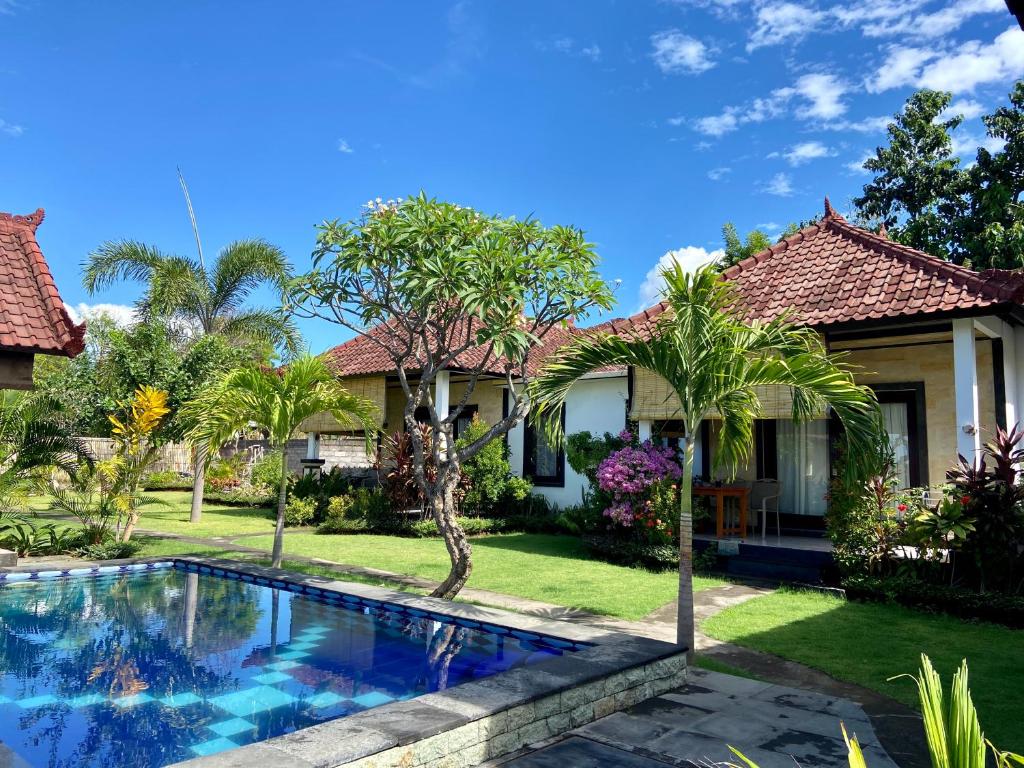 图兰奔Wonder Dive Bali Tulamben Villa's的庭院前带游泳池的房子