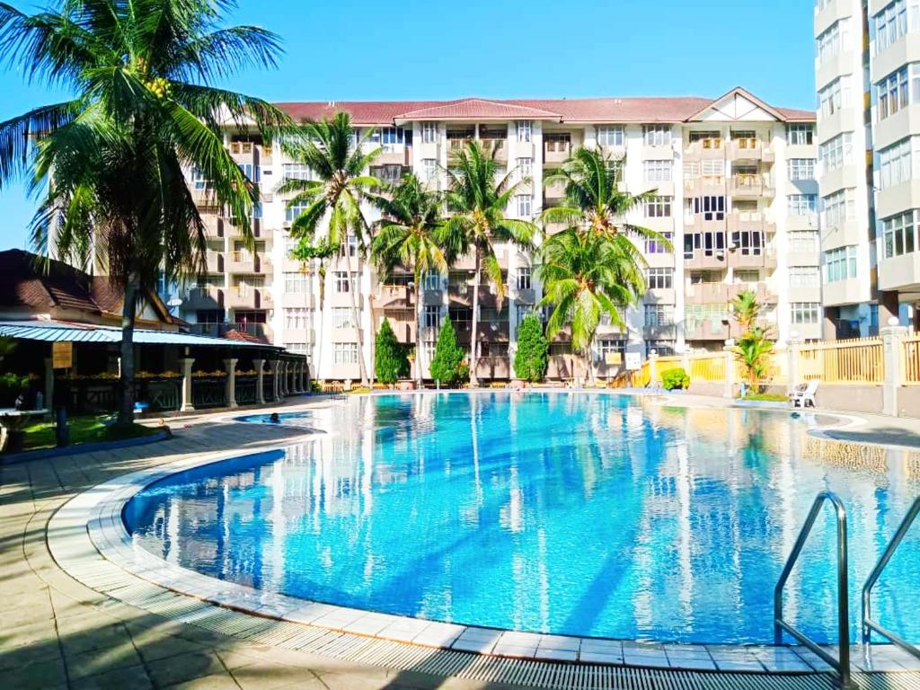 Kampong Tanah MerahD'Mentari Ocean View Resort Studio的一座棕榈树和建筑的大型游泳池