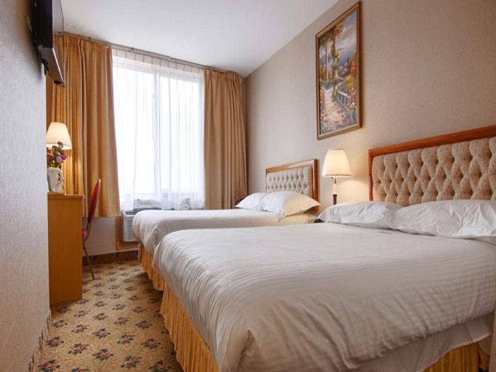 皇后区发达盛大酒店的酒店客房设有两张床和窗户。