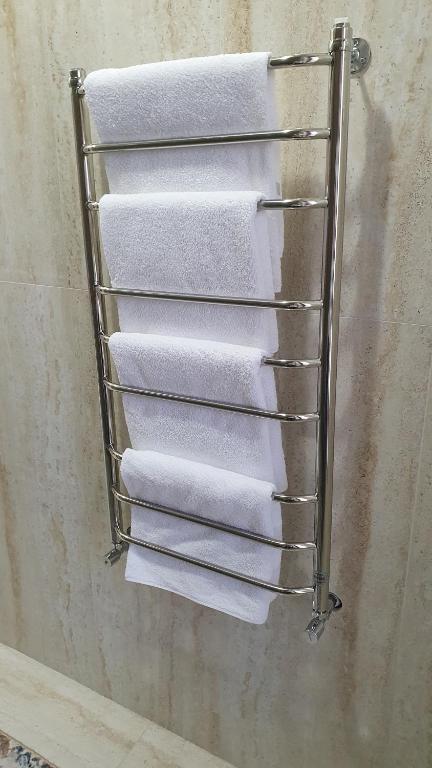 TürkistanKERUEN SARAY APARTMENTS 6/2的浴室内毛巾架和白色毛巾