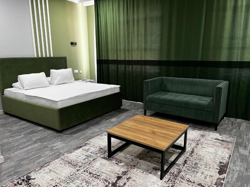 阿克托比KRich Hotel Aktobe的一间卧室配有一张床、一张沙发和一张桌子