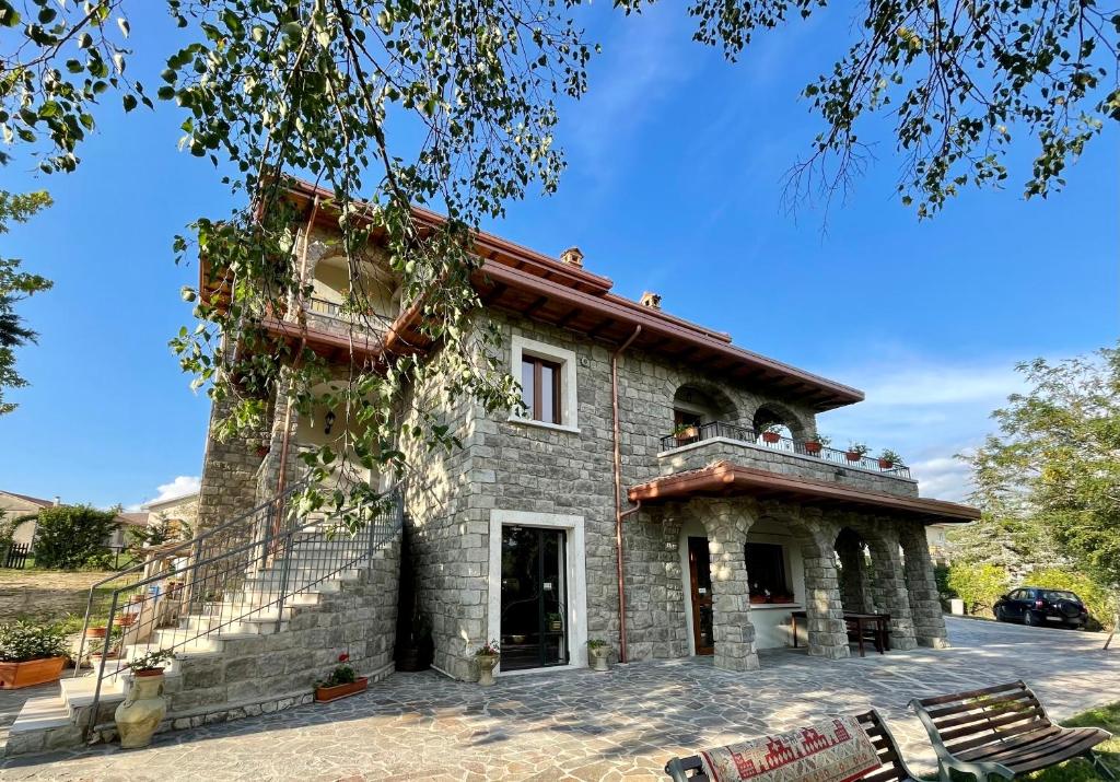 Cagnano AmiternoAgriturismo Cupello的石头房子的一侧设有阳台