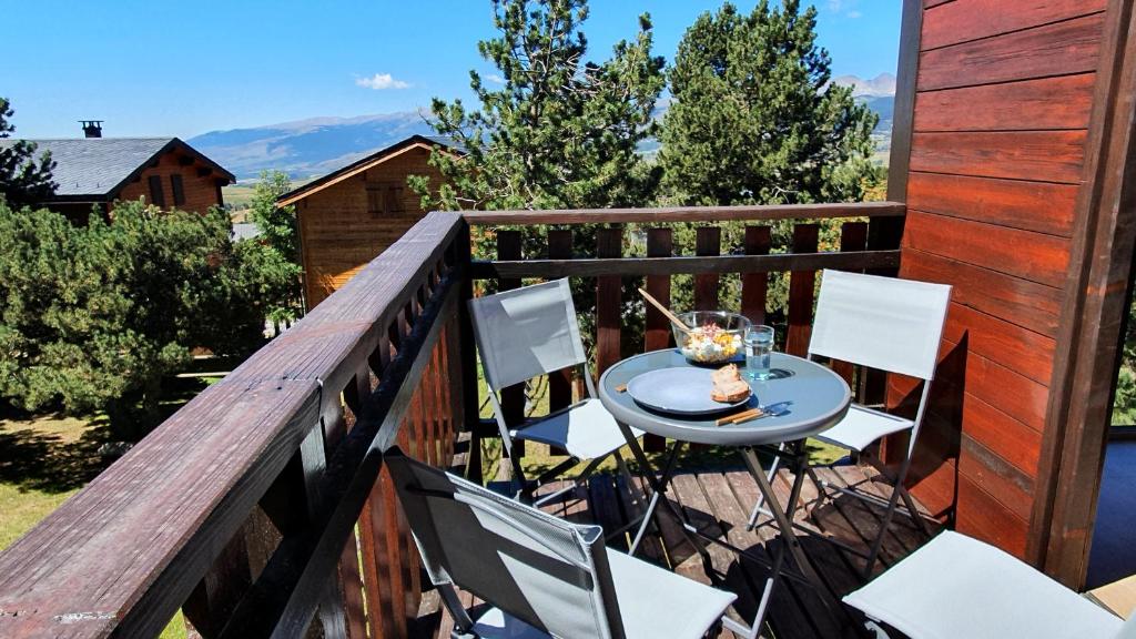 埃安Chalet Individuel Les Sorbiers - 80m2 - Jardin - Barbecue - Wifi - Netflix - Ski & Randonnée - Pyrénées Catalanes Françaises -的阳台配有桌椅,位于甲板上